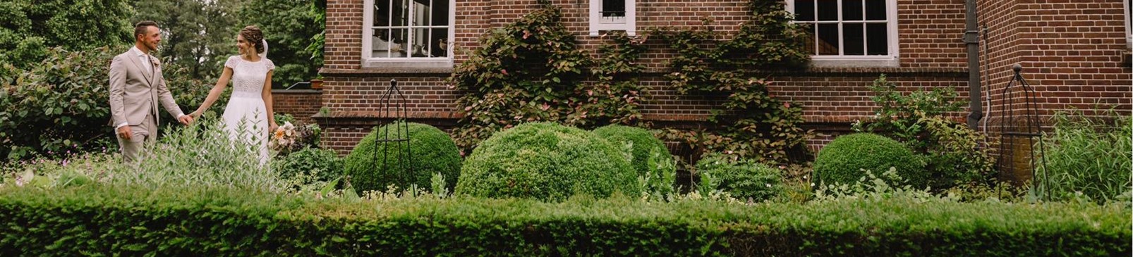 Bruidspaar bij een kasteel in trouwkleding van Atelier Speksnijder