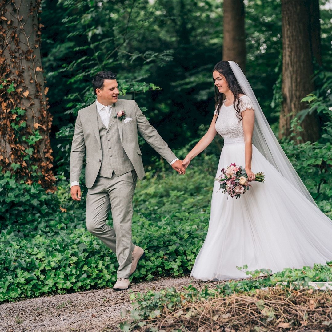 Bruidspaar in trouwkleding van Atelier Speksnijder, de foto's zijn gemaakt door Huibert van den Bos Fotografie