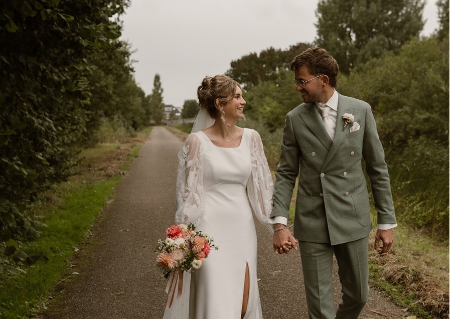 Couple walking hand in hand outdoors.