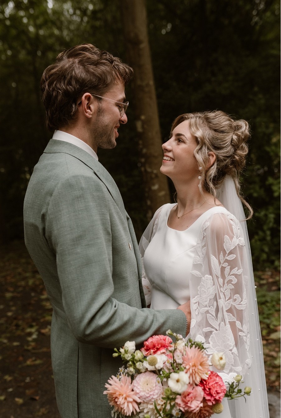 Couple smiling in a forest setting.