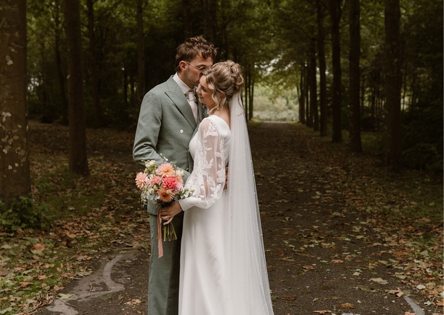 Couple embracing in a forest setting.