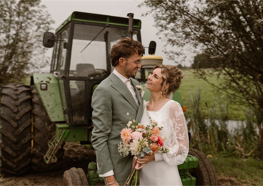 Couple posing by a tractor.