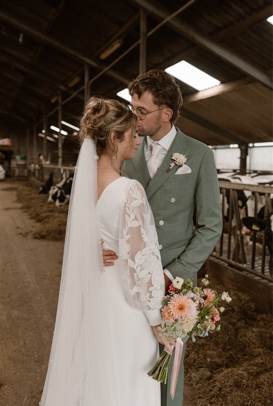 Bride and groom in a barn.