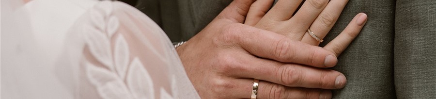 Couple's hands with wedding rings.